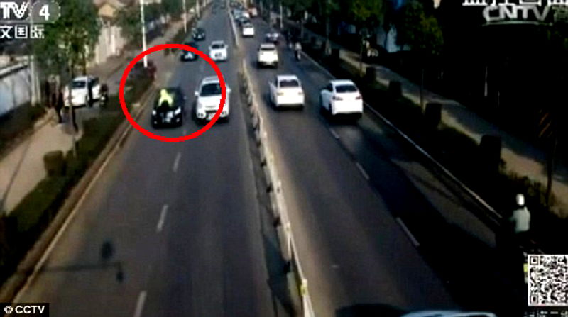 Badass Chinese Policeman Jumps on Car As It Speeds Away