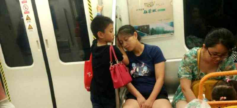 Boy Lets Exhausted Mother Use His Hand as a Pillow on Subway in China