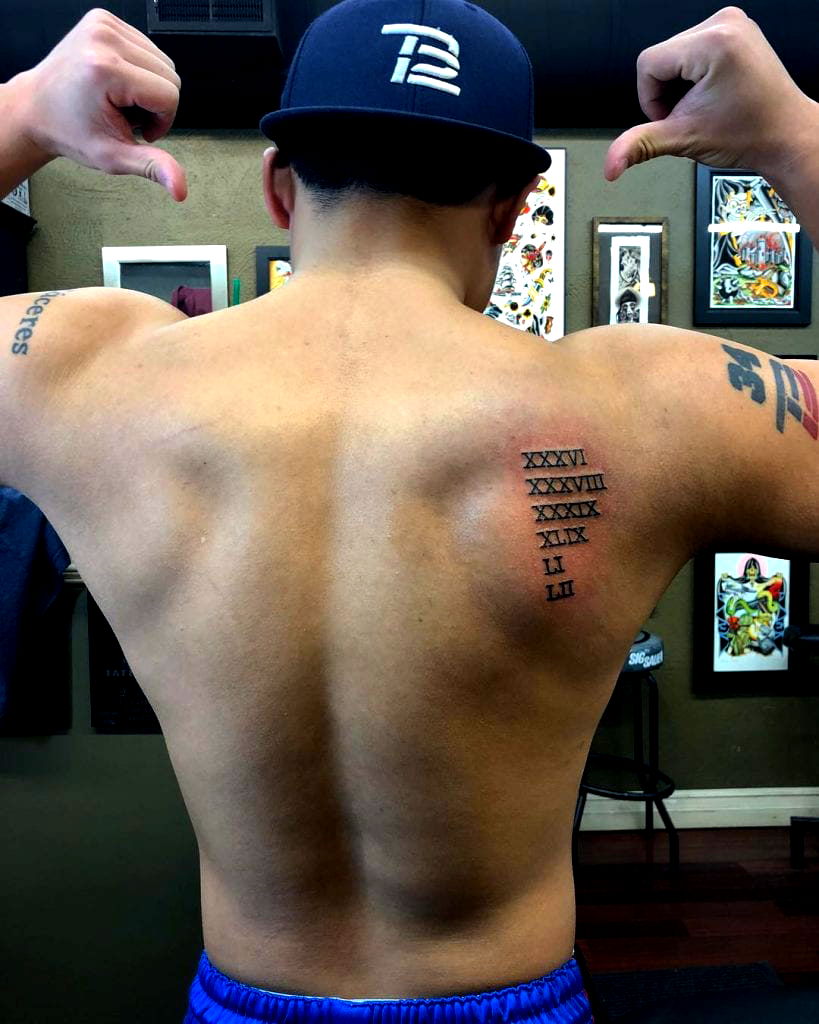 A fan of the Boston Red Sox displays his tattoos before a game