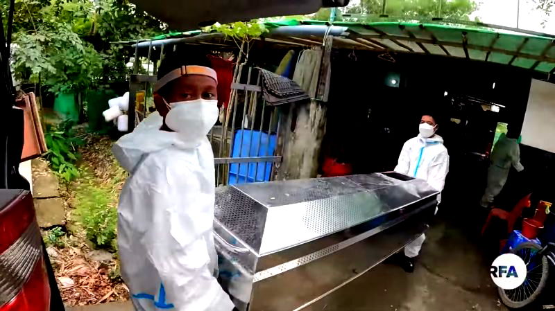 Tun Lin Naing (left) carries a casket.